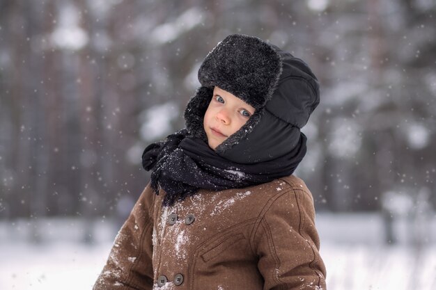 Porträt eines kleinen Jungen in einem Winterwald