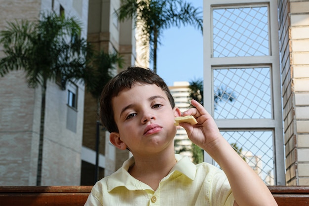 Porträt eines kleinen Jungen mit einem Schokoriegel