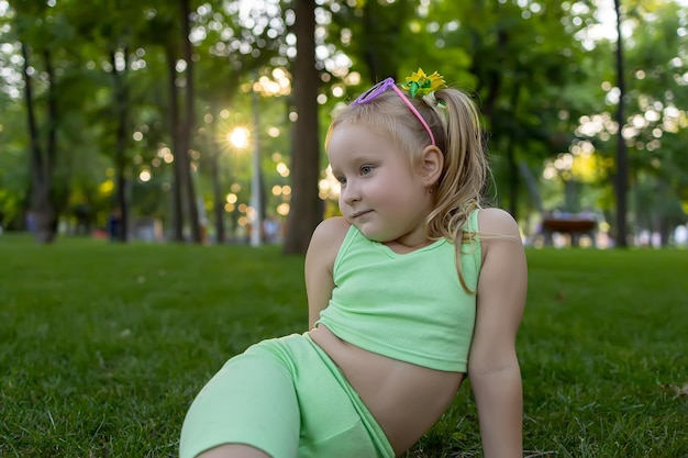 Porträt eines kleinen Mädchenmodells, das im Park für die Kamera posiert