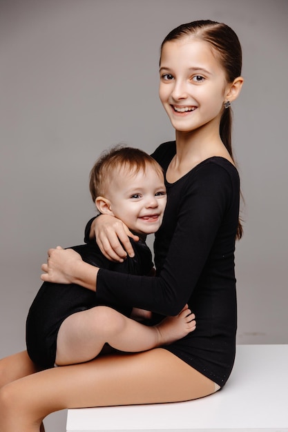 Porträt eines kleinen Mädchens, das glückliche Kinder der Schwester umarmt