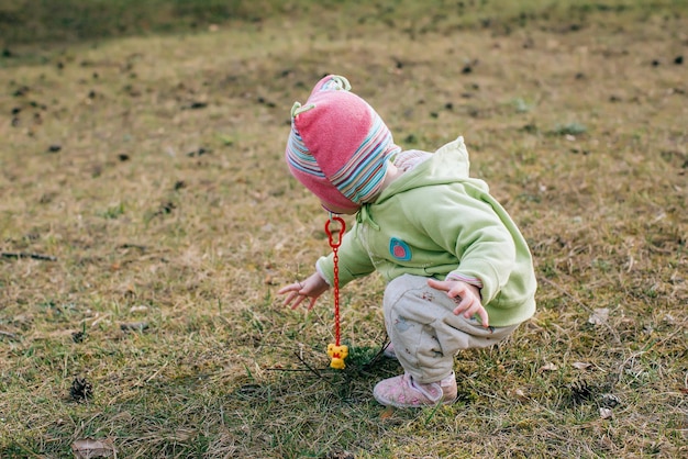 Porträt eines kleinen Mädchens im Freien, das Blumen auf dem Rasen sammelt