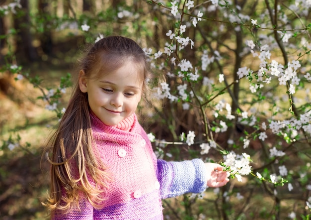 Porträt eines kleinen Mädchens in einem Blumengarten