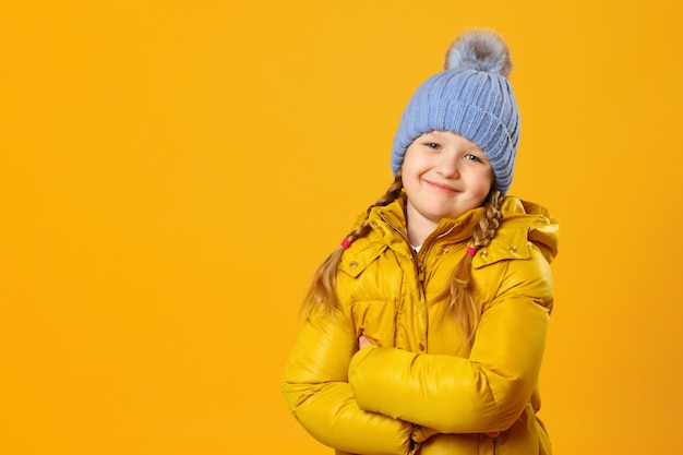 Porträt eines kleinen Mädchens in einem Hut und in einer Jacke.