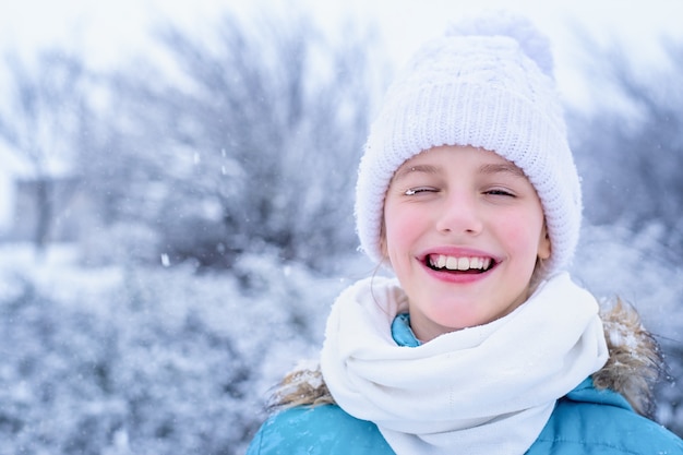 Foto porträt eines kleinen mädchens in winterkleidung mit schneeflocken auf ihren wimpern.