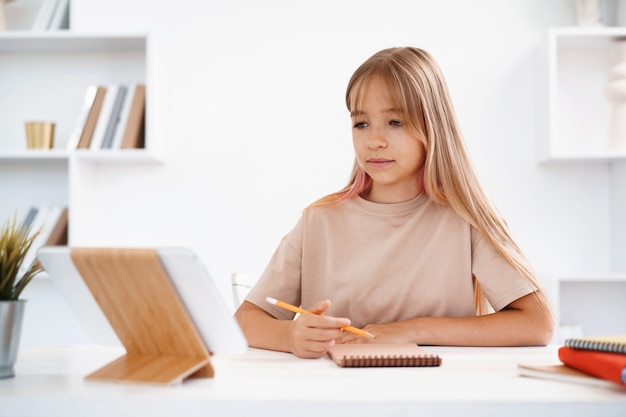 Porträt eines kleinen Mädchens mit digitalem Tablet-Computer zu Hause