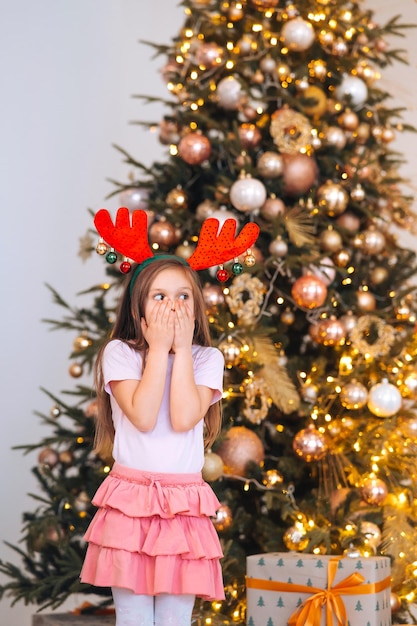 Porträt eines kleinen Mädchens mit Hirschweihnachtsmütze Winterferien und Personenkonzept