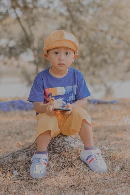Porträt eines Kleinkindes, das auf dem Feld sitzt