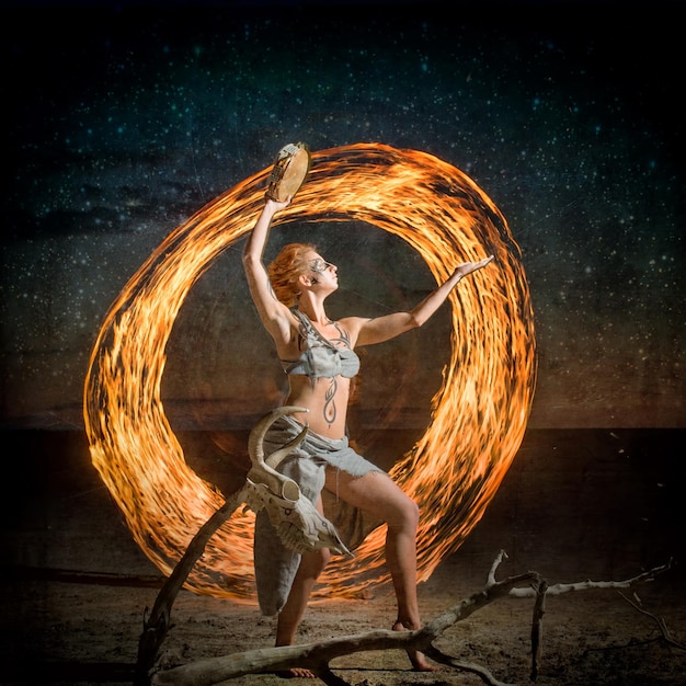 Porträt eines körperbemalten Mädchens, das mit der Flamme tanzt