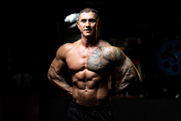 Porträt eines körperlich fitten Mannes, der seinen gut trainierten Körper zeigt muskulöser athletischer Bodybuilder Fitness Model posiert nach Übungen
