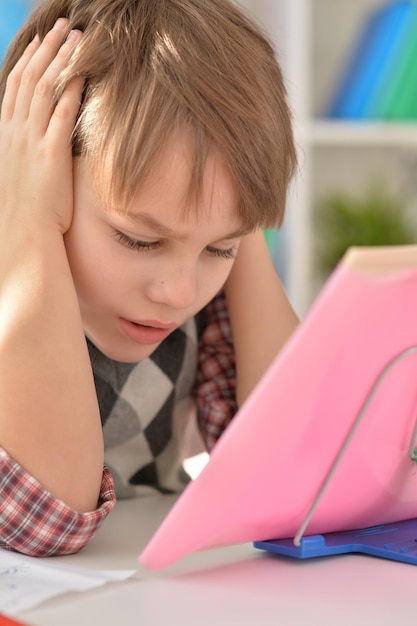 Foto porträt eines konzentrierten kleinen jungen, der seine hausaufgaben macht