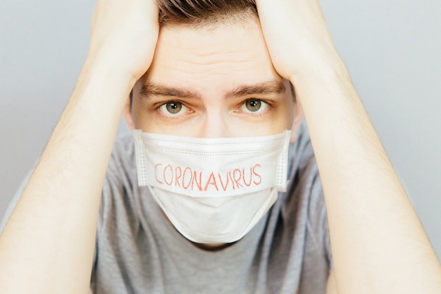 Foto porträt eines kranken mannes, der medizinische maske mit coronavirus-textkonzept trägt. schützen sie ihre gesundheit. pandemie