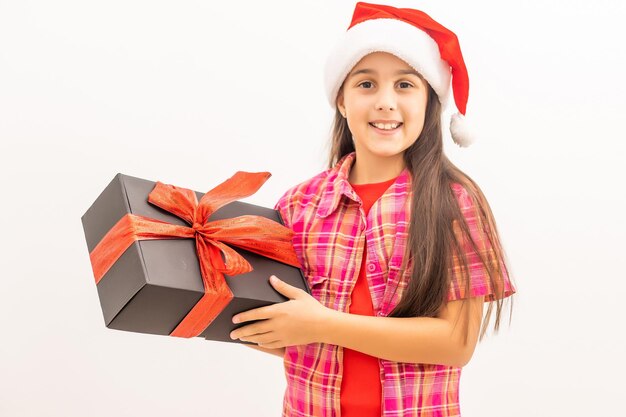 Porträt eines lachenden kleinen mädchens, das weihnachtsdekoration in den händen auf weißem hintergrund hält