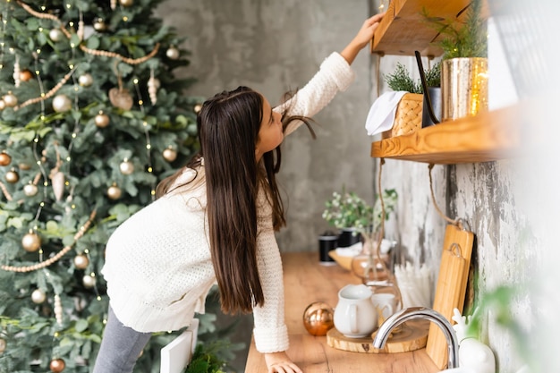 Porträt eines lachenden kleinen Mädchens, das Weihnachtsdekoration in den Händen hält.