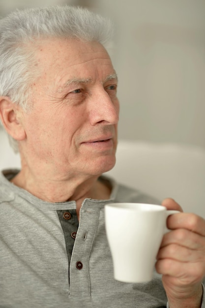 Porträt eines lächelnden älteren Mannes, der Kaffee trinkt