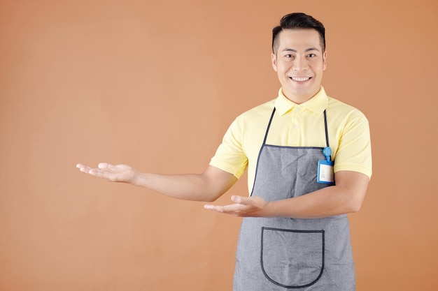Porträt eines lächelnden asiatischen gastfreundlichen Kellners, der Kunden im Coffeeshop oder Café begrüßt