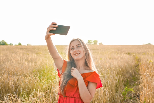 Porträt eines lächelnden jungen Mädchens, das Selfie-Foto im Feld macht