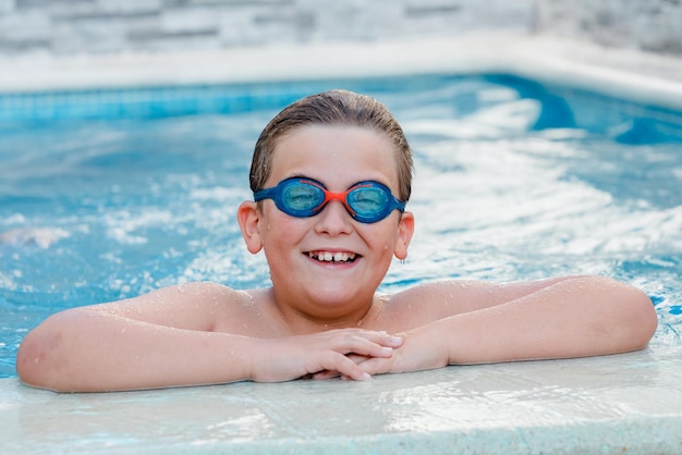 Porträt eines lächelnden jungen Mannes, der im Pool schwimmt