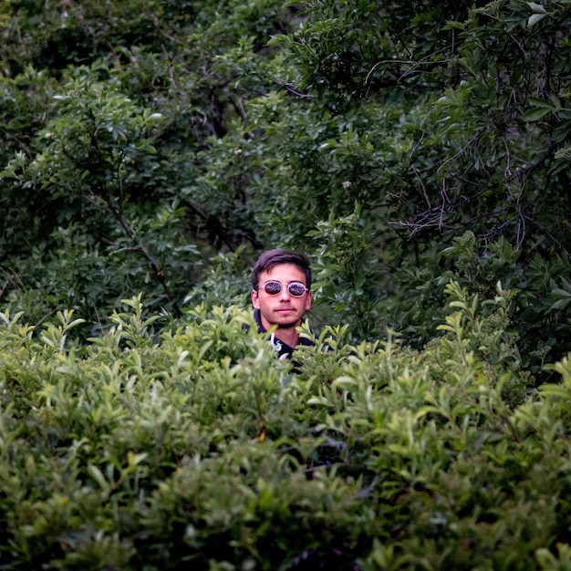 Foto porträt eines lächelnden jungen mannes im wald