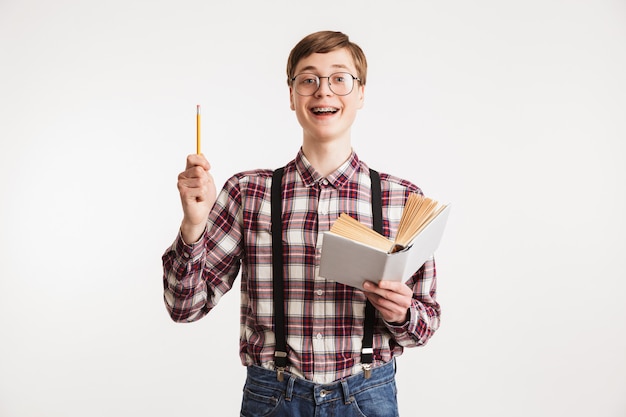 Porträt eines lächelnden jungen Schul-Nerd-Kerls, der Buch hält