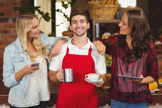 Foto porträt eines lächelnden kellners und der kunden an der kaffeestube