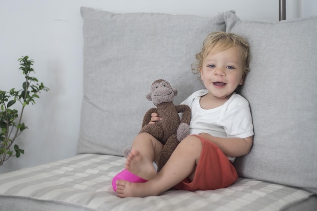 Porträt eines lächelnden Mädchens, das auf dem Sofa sitzt