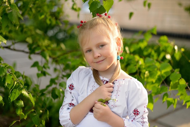 Porträt eines lächelnden Mädchens mit einer Blume in einem ukrainischen bestickten Hemd Ukrainische Traditionen