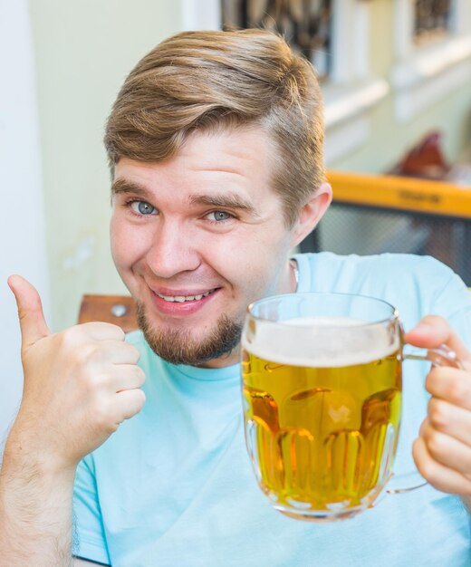 Foto porträt eines lächelnden mannes mit einem getränk
