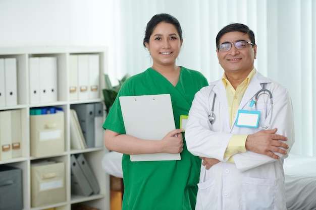 Porträt eines lächelnden multiethnischen Ärzteteams mit Zwischenablage