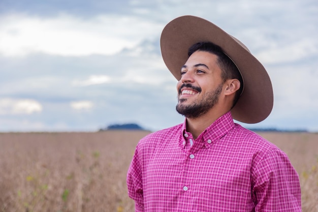 Porträt eines lächelnden, schönen jungen männlichen Bauern Mann auf der Farm im Sommertag Gartenarbeit Brasilianischer Mann
