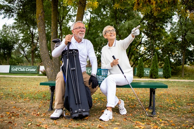 Porträt eines lächelnden Seniorenpaares auf dem Golfplatz genießen Sie das Spielturnier