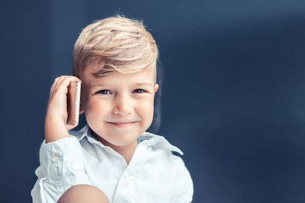 Porträt eines lächelnden süßen Jungen mit Handy