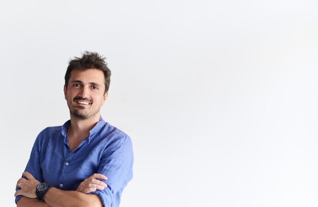 Porträt eines lässigen Startup-Geschäftsmanns mit verschränkten Armen, der ein blaues Hemd trägt, das auf weißem Hintergrund isoliert ist
