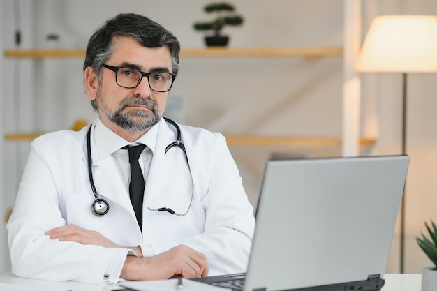 Porträt eines leitenden Arztes im weißen Kittel am Arbeitsplatz