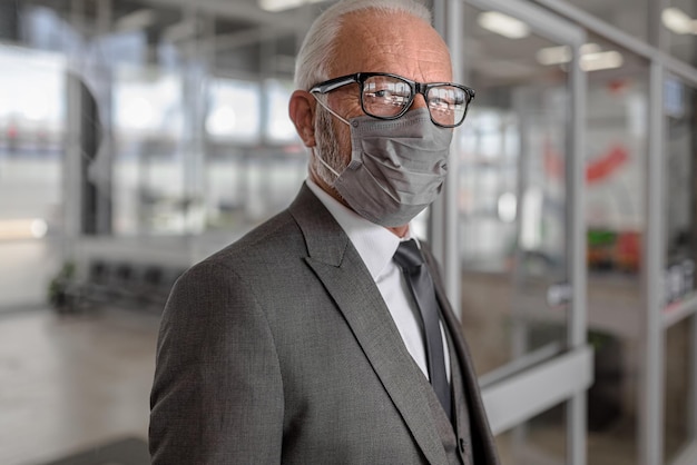 Porträt eines leitenden Geschäftsmannes mit Schutzmaske