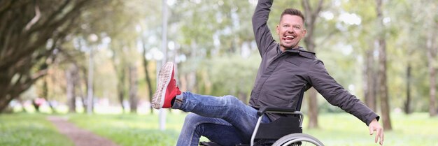 Foto porträt eines lustig lächelnden behinderten mannes, der mit einem basketballball spielt, der im rollstuhl sitzt