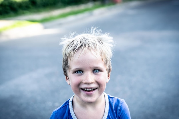 Porträt eines lustigen, fröhlichen, schelmischen, fröhlichen, süßen, blonden, blauäugigen Jungen, der Sommersprossen schmutziges Gesicht macht, während er lachend spielt Kindergarten glückliche Kindheit Bildung Familienbeziehung Konzept