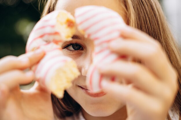 Porträt eines Mädchens, das Donut hält und durchschaut
