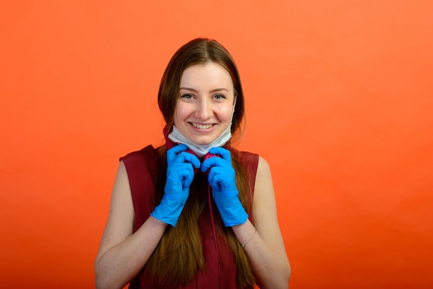Porträt eines Mädchens, das eine Gesichtsmaske auf einem blauen Hintergrund trägt