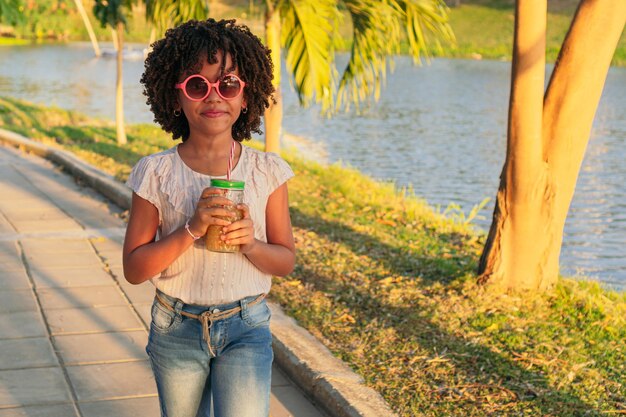 Porträt eines Mädchens, das während der Ferien in einem Park spazieren geht Sommerkonzept
