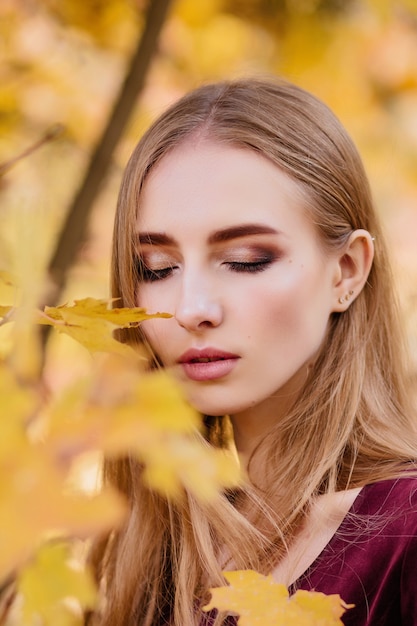 Porträt eines Mädchens im gelben Herbstlaub