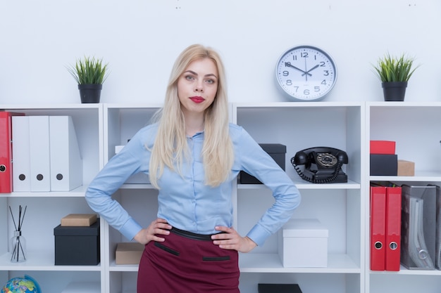 Porträt eines Mädchens in einem blauen Hemd und einem roten Rock im Büro