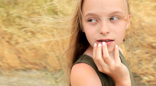 Porträt eines Mädchens mit blonden Haaren im Sommer auf dem Feld