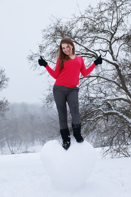 Porträt eines Mädchens mit einem großen schneebedeckten Herzen