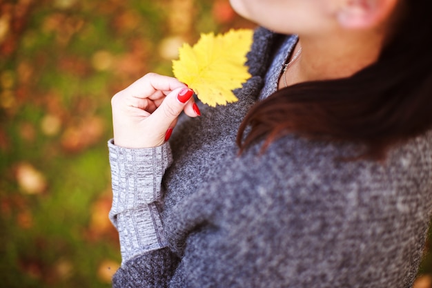 Porträt eines Mädchens mit einem Herbstblatt in der Hand
