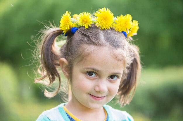 Porträt eines mädchens mit einem kranz aus löwenzahn fünfjähriges baby in wildblumen