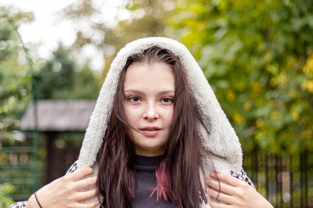 Porträt eines Mädchens mit einem zielstrebigen Look, gekleidet in eine Demiseseason-Jacke mit Kapuze