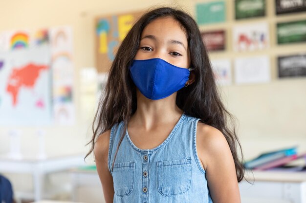 Porträt eines Mädchens mit Gesichtsmaske in der Schule