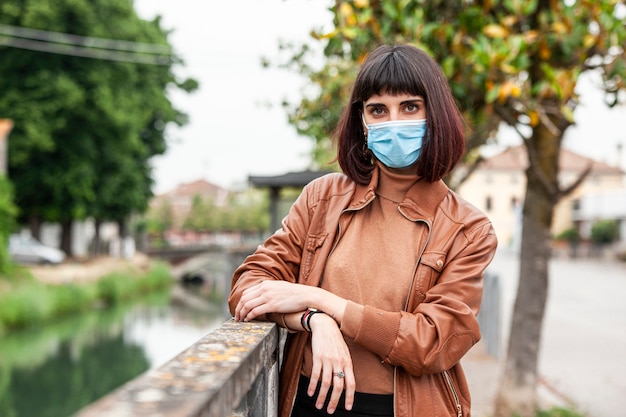 Foto porträt eines mädchens mit medizinischer maske im freien während der covid-quarantäne in italien