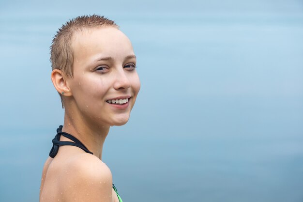 Porträt eines Mädchens mit Tropfen im Gesicht nach dem Schwimmen