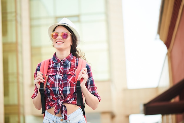 Porträt eines Mädchentouristen mit Hut und Sonnenbrille in der Stadt